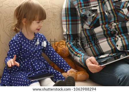 Cute little girl on couch with dad use cellphone calling mom portrait. Life style apps social web network wireless ip telephony concept