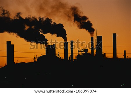 This is a Ford factory at sunset. These are smokestacks contributing to the pollution in the air.