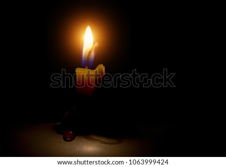 One candle flame light at night with on dark background