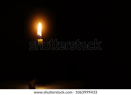 One candle flame light at night with on dark background