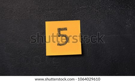 Note with number "5" on the blackboard