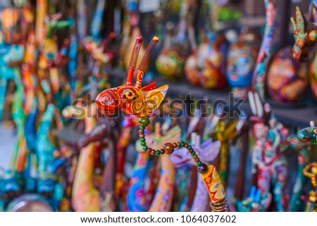 Colorful souvenir background. Souvenir shop selling souvenirs and handicrafts. Handmade wooden giraffe. Sale of souvenirs. Funny giraffes with bright colorful patterned. Selective focus.