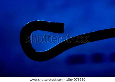 Silhouette of a hook on a blue background, photo