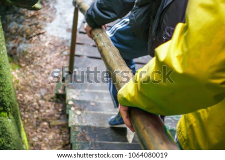 people hold on to the wooden handrail