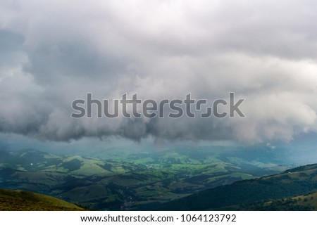 Storm rainy clouds above mountains. Apocalypse fantasy fabulous sky. Beautiful windy dramatic cloudscape at nature. Picturesque scenic view outdoor. Travel in wild territory. Discover rocky hills.