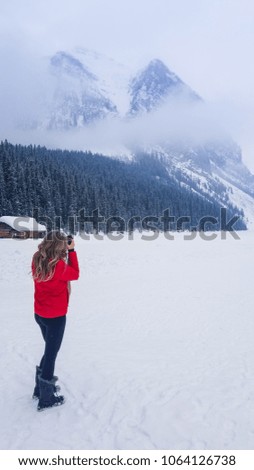 Woman taking a photo at Lake Louise in Alberta, Canada