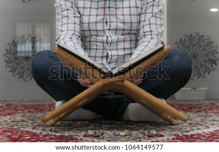 Young muslim man reading the Quran - holy book of Muslims