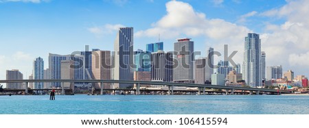 Miami skyscrapers with bridge over sea in the day.