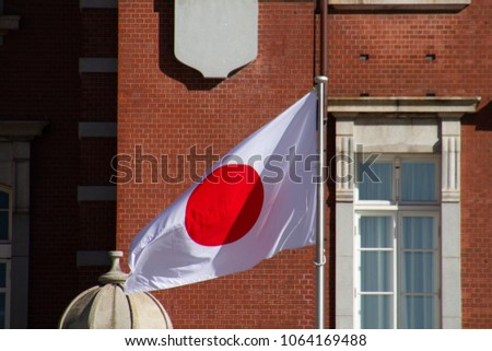 Japanese flag in front of an old 19th century style brick building.