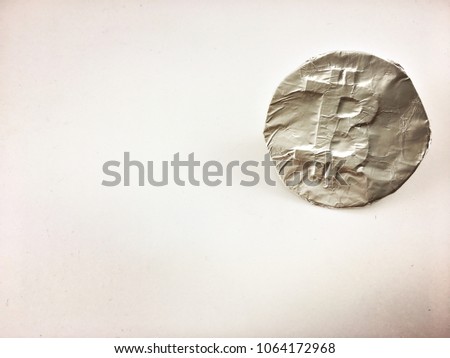 Photograph of handmade Bitcoin symbol made of foil isolated. Concept art handicraft pretend bitcoin made of foil 
