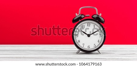 alarm clock on a red background on the blackboard