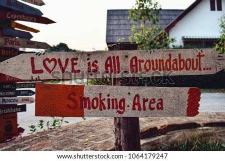 Handmade wooden sign with smoking area text at hostel for backpackers.