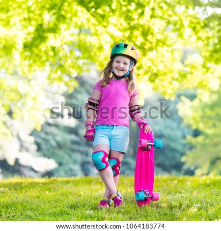 Child riding skateboard in summer park. Little girl learning to ride skate board. Active outdoor sport for school and kindergarten kids. Children skateboarding. Preschooler on longboard. Kid skating.