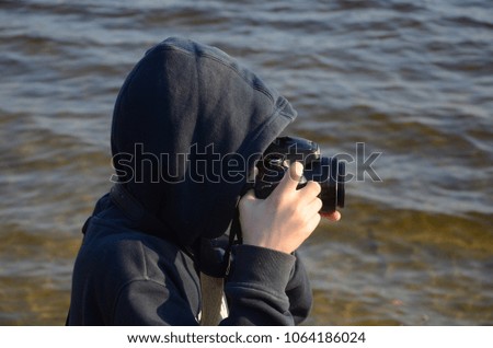 Young photographer on the river bank