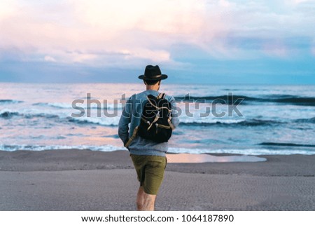 Young attractive traveler with a backpack at the beach mockup