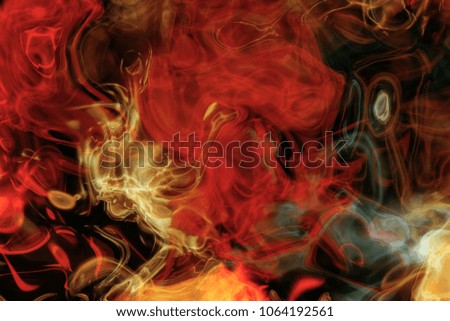 Colored abstract smoke and fire on a black background.