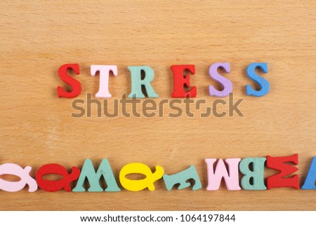 STRESS word on wooden background composed from colorful abc alphabet block wooden letters, copy space for ad text. Learning english concept