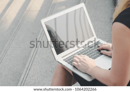 attractive hand of business woman using laptop working typing key board sit on concrete stair at outdoor in the city.