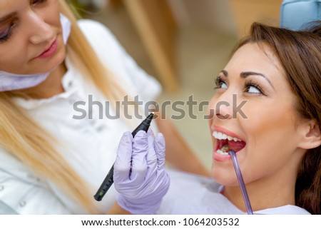 Close-up of beautiful young woman in visit at the dentist office and dentist repair her teeth. 