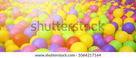 Many colorful plastic balls in a kids' ballpit at a playground. Close up pattern