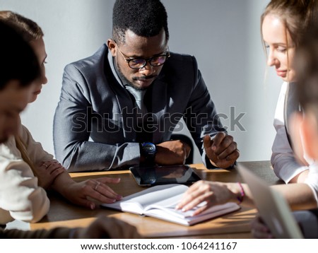 afroamerican Team leader talking with coworkers in modern office