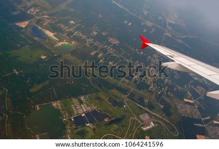 Airplane wing with blue sky and clouds as a background. Picture for copy space, text message and advertisement. Traveling and tourism concept.