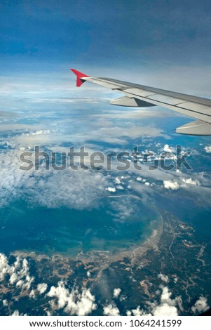 Airplane wing with blue sky and clouds as a background. Picture for copy space, text message and advertisement. Traveling and tourism concept.