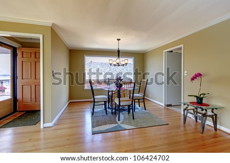 Dining room with front door and hardwood floor and round glass table