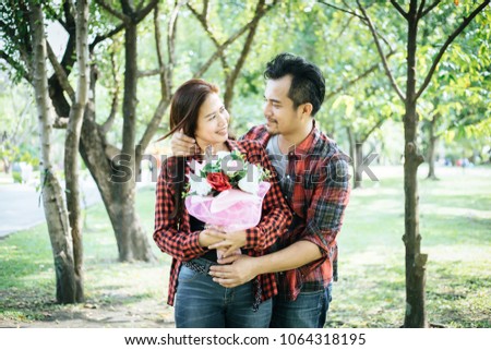 Close-up of a man giving happy woman flowers.A picture of a romantic couple getting.