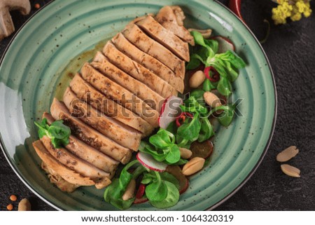 Chicken steak roasted and salad, food photography. Black background. Top view.