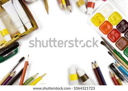 Art materials, pencils, brushes and paints are photographed on light background, top view. Isolated.