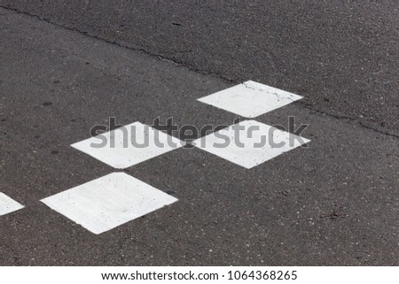 white marking on the road from the painted squares, closeup on the roadway