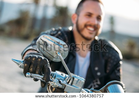 close-up of a biker with jacket and leather gloves in nature place