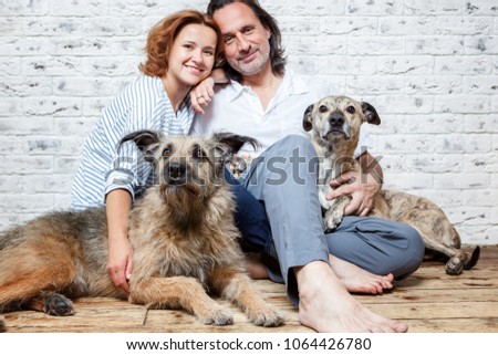 A happy married couple with their dogs, a seed portrait, love, care, friendship, devotion