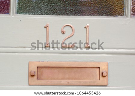 House number 121 sign and letterbox on door