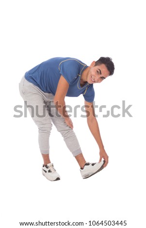 Full-length shot of a player touches his foot stretching, isolated on a white background.