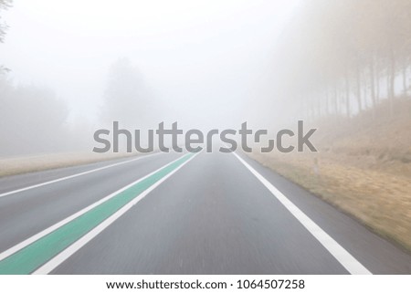 on a foggy road along nature with a limited view