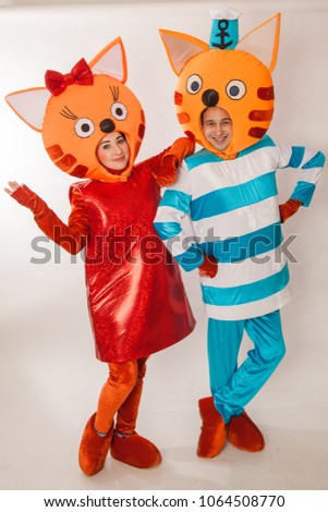 Young girl and guy in the chic costumes of cats