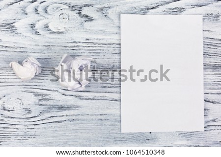 Crumpled and blank sheet for text or mockup on a white wooden table