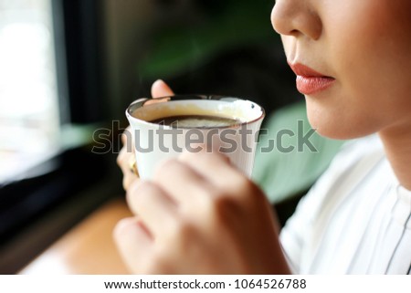 Beautiful young woman drink hot coffee.