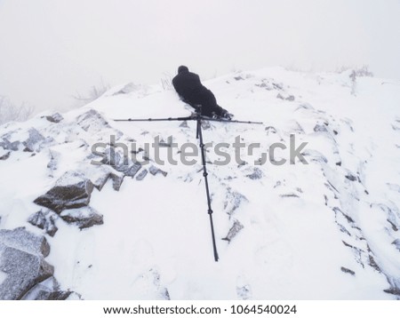 Silhouette of photographer with tripod in the fog.. Photographer works in foggy winter landscape