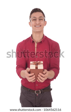 Young man giving a gift and smiling isolated on a white background