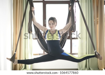 yoga in a hammock girl / concept sport active lifestyle. young coach doing yoga in a hammock, gym, fitness, training in a hammock