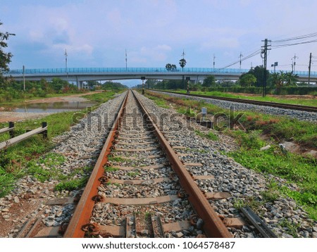 Railroad tracks with blue sky and forest