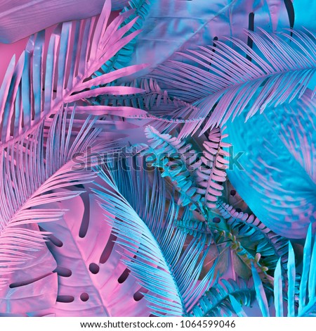 Tropical and palm leaves in vibrant bold gradient holographic neon  colors. Concept art. Minimal surrealism background. Royalty-Free Stock Photo #1064599046