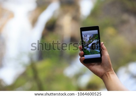 Woman tourist taking photo with smart phone 