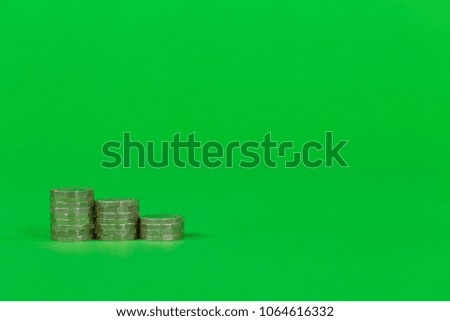 Stacked Coins on a Green Background Royalty-Free Stock Photo #1064616332