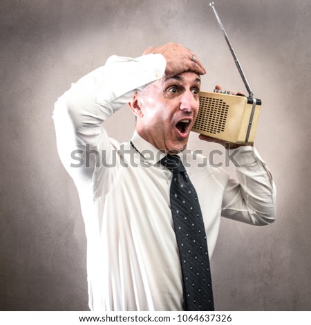 Businessman listening to the radio making strange expressions