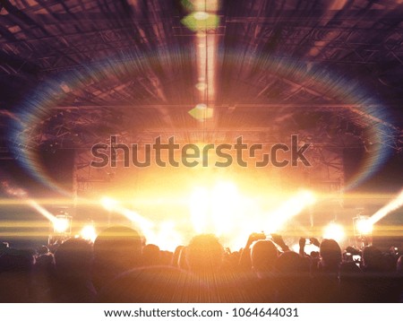 Concert venue with silhouettes of heads and hands clapping