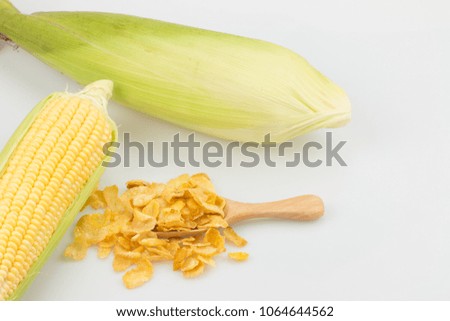 Fresh corn and cornflakes on white background